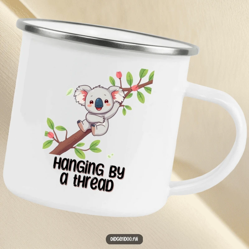 Funny koala camping mug showing a playful character joyfully dangling from a eucalyptus branch, perfect for relaxed outdoor enjoyment.