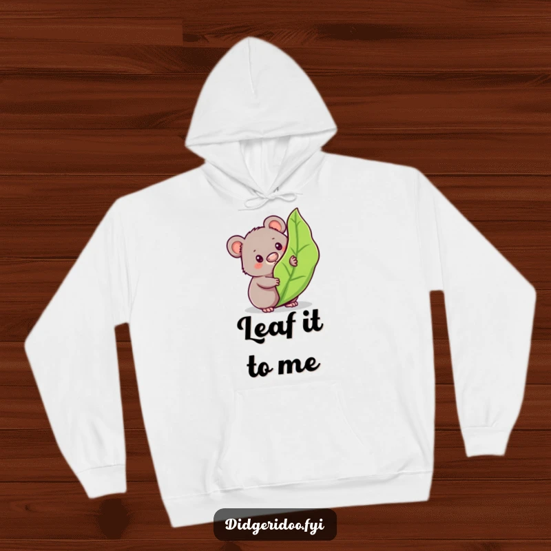 Funny wombat hoodie featuring a curious character peeking from behind a bouncy gum leaf, offering cozy Aussie charm and mystery.