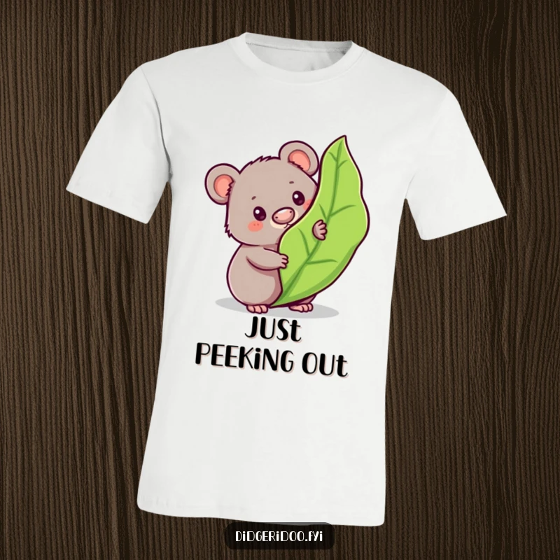 Funny wombat t-shirt depicting a curious character peeking from behind a bouncy, stylized gum leaf, showcasing playful Aussie spirit.